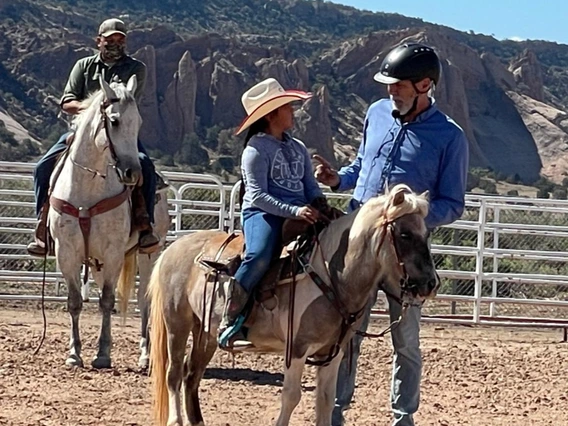 clinician gives instructions to youth rider on pony