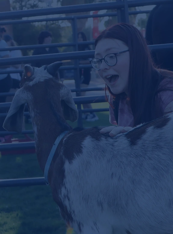 Student with a goat at Animal Encounters Day event