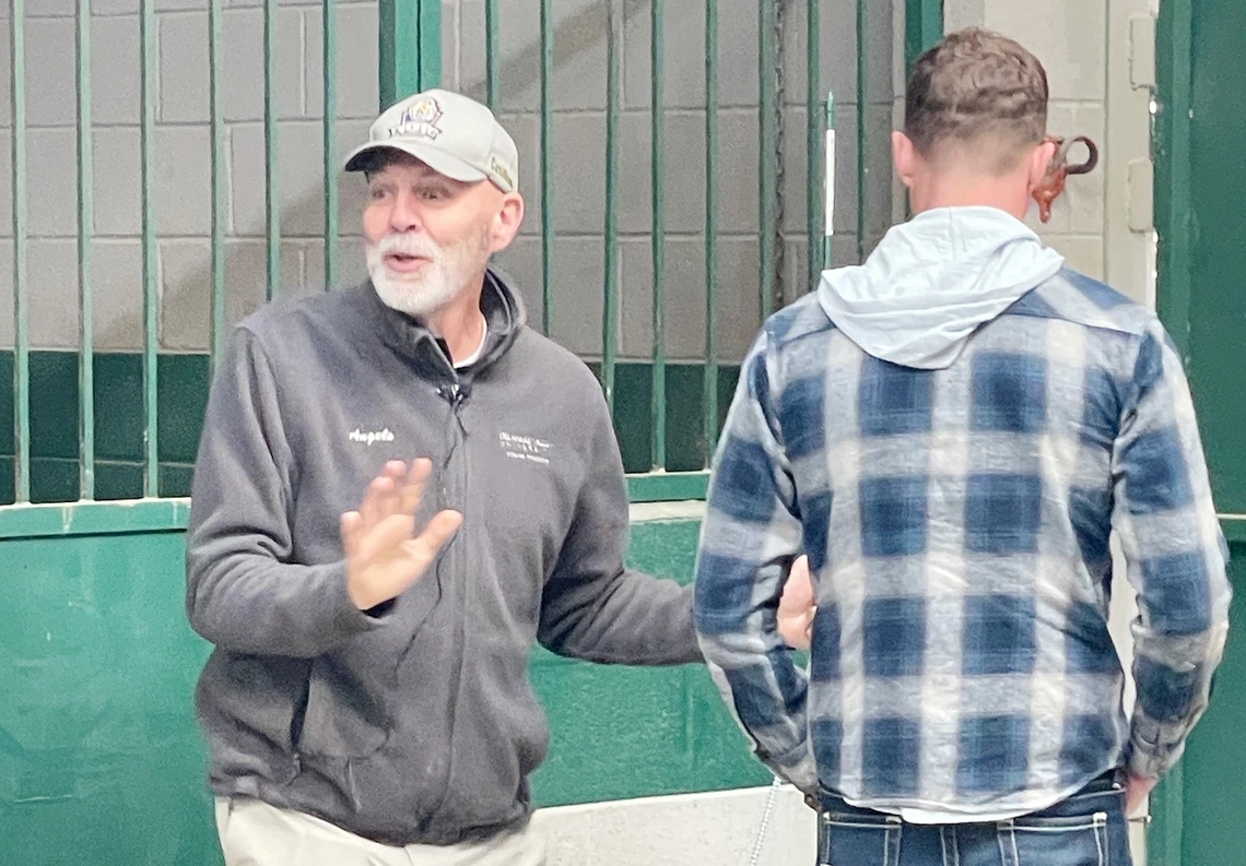 Man standing facing forward next to man standing facing backward