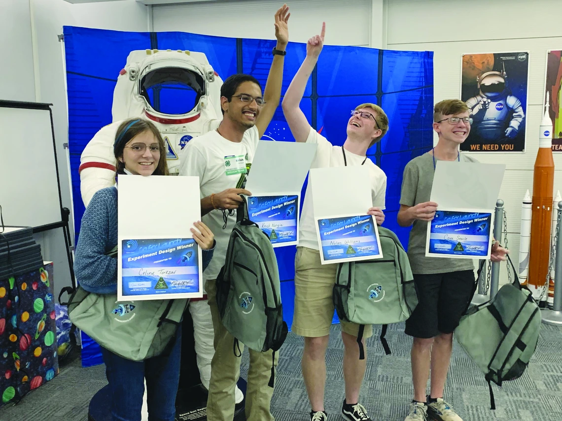 Four student team members with awards