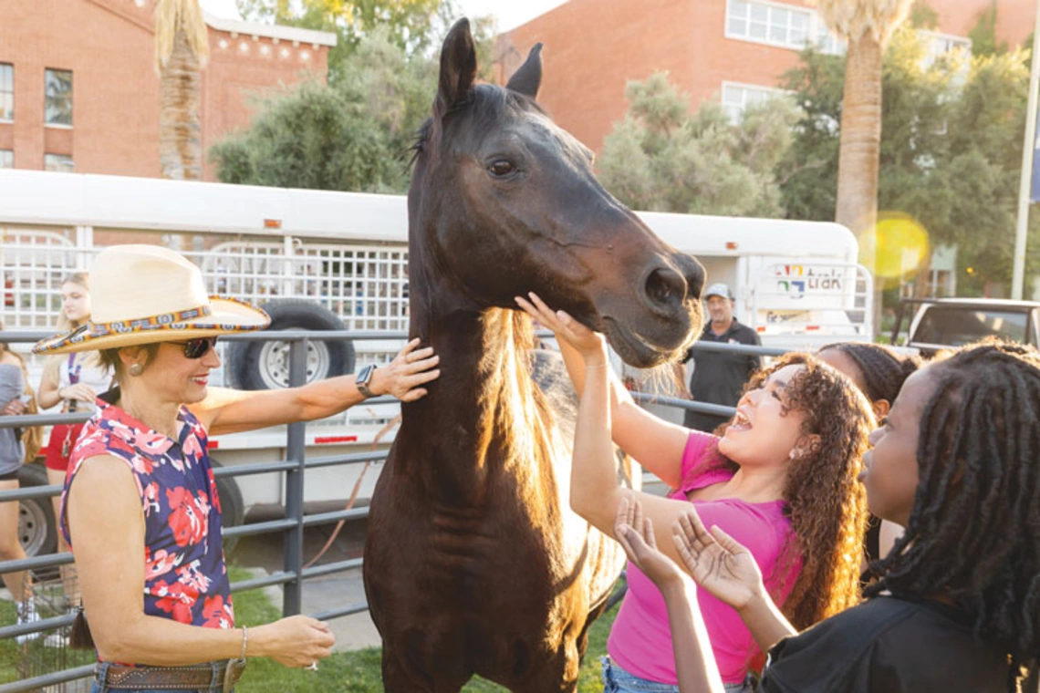 Dr. Netzin Steklis standing with horse and two students