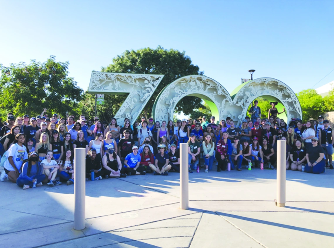 class in front of zoo sign